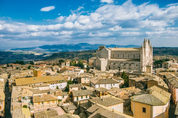 aerial view of Orvieto Cathedral and buildings with mountains on background in Orvieto, Rome suburb,